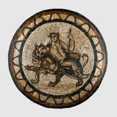 This mosaic is of earlier date than most surviving mosaics from Roman-Britain. It features Bacchus, riding on a tiger rather than the more usual spotted leopard, referring to the myth that the god visited India. Appropriately enough, the mosaic was discovered during building work on the premises of the East India Company. The design of the floor was recorded, and it was lifted in sections. During the nineteenth century, the owners allowed the fragments to be stored in the open air, and their condition deteriorated. Three sections, including the central roundel, were subsequently restored, and though the tesserae are in their correct positions according to the early engravings, the present smooth, polished surface represents Victorian conservation rather than the original Roman appearance. The surviving pieces were eventually transferred to The British Museum in 1880. Diameter: 114 cm